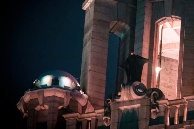 The Caped Crusader stands atop the Liver Building during filming of The Batman