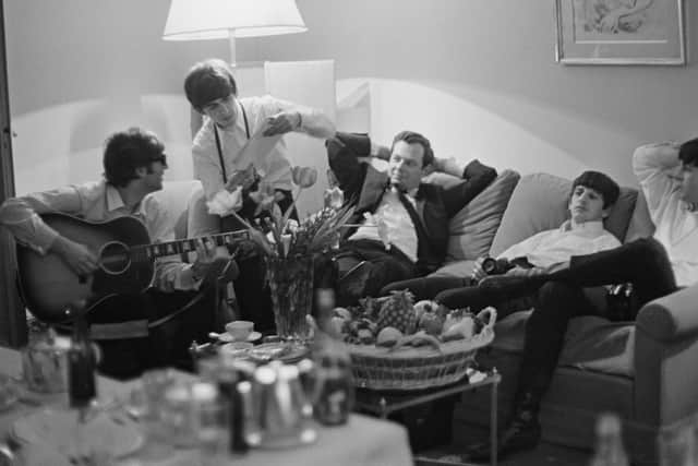 The Beatles and manager Brian Epstein relax in a hotel room in Paris. Photo: Harry Benson/Getty Images