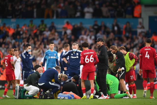 LEEDS, ENGLAND - SEPTEMBER 12: Harvey Elliott of Liverpool (obscured) receives medical treatment during the Premier League match between Leeds United and Liverpool at Elland Road on September 12, 2021 in Leeds, England. (Photo by Laurence Griffiths/Getty Images)