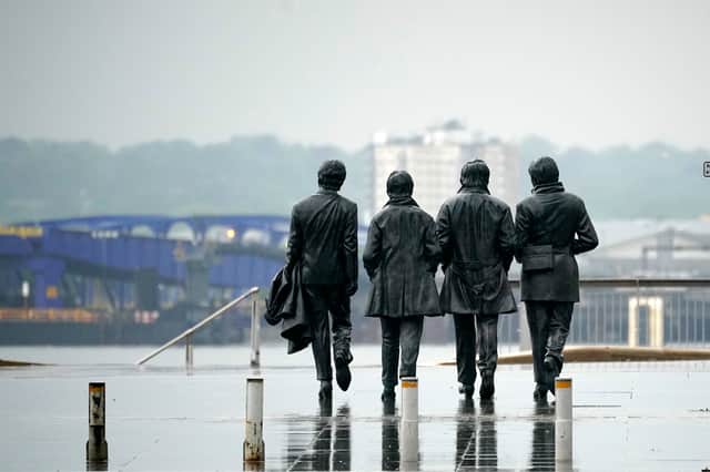 The Beatles statue looks out over the River Mersey on a near deserted Pier Head during rain. (Photo by Christopher Furlong/Getty Images)