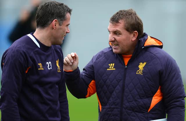 Jamie Carragher speaks with Brendan Rodgers during Liverpool training. Picture: ANDREW YATES/AFP via Getty Images