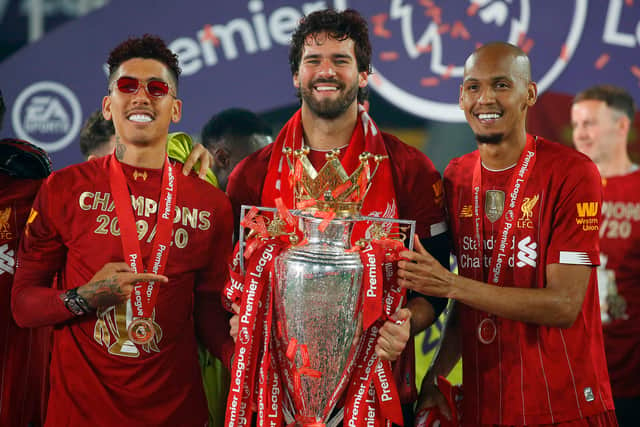 From left: Brazilian dup Roberto Firmino, Alisson and Fabinho celebrate Liverpool winning the Premier League. Picture:  PHIL NOBLE/POOL/AFP via Getty Images