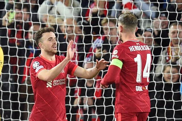 Diogo Jota celebrates opening the scoring in Liverpool’s defeat of Atletico Madrid with Jordan Henderson. Picture: OLI SCARFF/AFP via Getty Images
