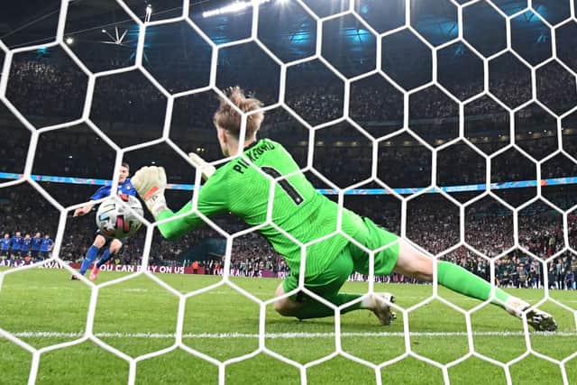 England’s goalkeeper Jordan Pickford saves a shot by Italy’s forward Andrea Belotti in the penalty shootout during the UEFA EURO 2020 final football match between Italy and England at the Wembley Stadium in London on July 11, 2021. (Photo by Paul ELLIS / AFP) (Photo by PAUL ELLIS/AFP via Getty Images)