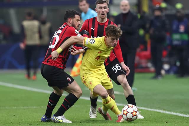 Kostas Tsimikas of Liverpool battles for possession with Alessandro Florenzi and Alexis Saelemaekers of AC Milan during the UEFA Champions League group B match between AC Milan and Liverpool FC at Giuseppe Meazza Stadium on December 07, 2021 in Milan, Italy
