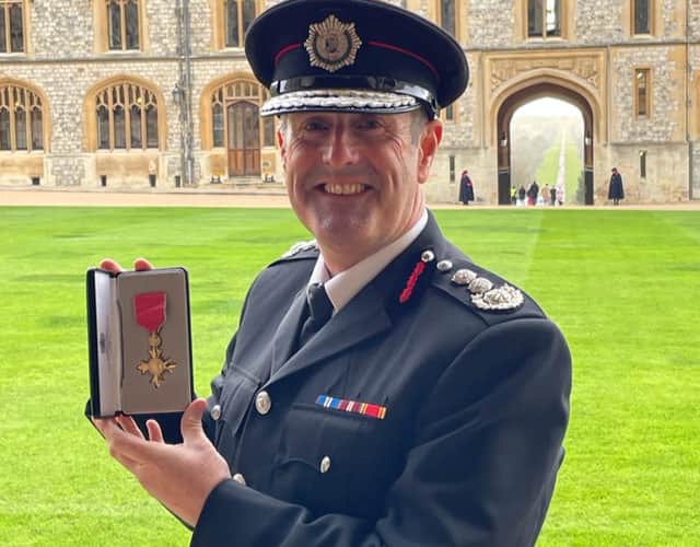 <p>Chief Fire Officer Phil Garrigan with his OBE.</p>