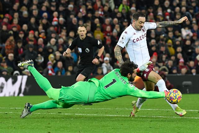 Alisson Becker and Danny Ings collide in the area. Photo: OLI SCARFF/AFP via Getty Images