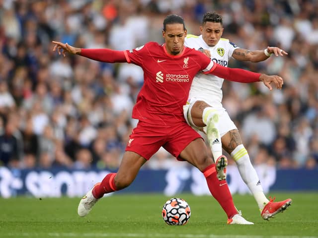Virgil van Dijk of Liverpool is challenged by Raphinha of Leeds United during the Premier League match between Leeds United and Liverpool at Elland Road on September 12, 2021 