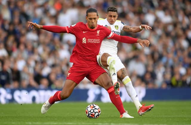 <p>Virgil van Dijk of Liverpool is challenged by Raphinha of Leeds United during the Premier League match between Leeds United and Liverpool at Elland Road on September 12, 2021 </p>
