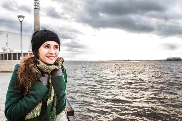 A woman wraps up warm on the Liverpool waterfront. Shutterstock