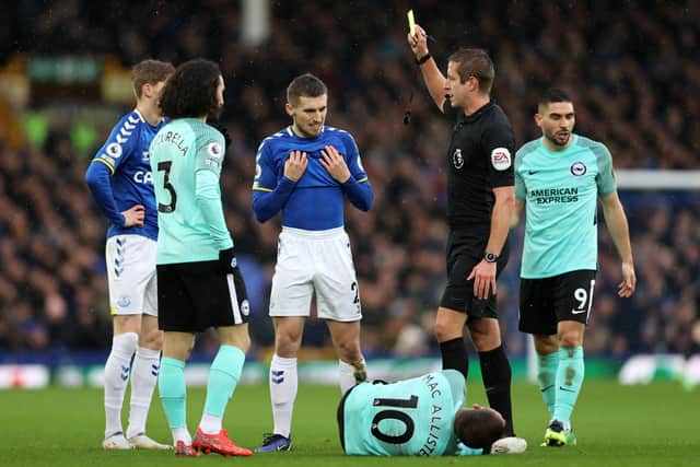 onjoe Kenny of Everton receives a yellow card from referee John Brooks during the Premier League match between Everton and Brighton & Hove Albion at Goodison Park on January 02, 2022 in Liverpool, England. (Photo by Clive Brunskill/Getty Images