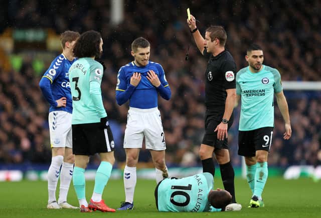 onjoe Kenny of Everton receives a yellow card from referee John Brooks during the Premier League match between Everton and Brighton & Hove Albion at Goodison Park on January 02, 2022 in Liverpool, England. (Photo by Clive Brunskill/Getty Images