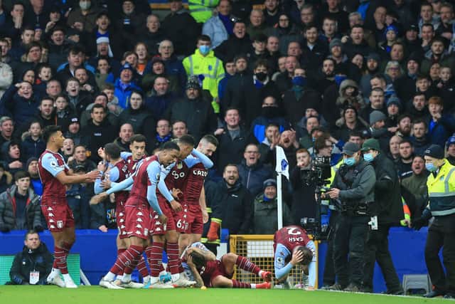 Aston Villa’s Matty Cash and Lucas Digne react after being struck by a bottle thrown from the crowd during their opening goal celebration during the English Premier League football match between Everton and Aston Villa at Goodison Park in Liverpool, north west England on January 22, 2022