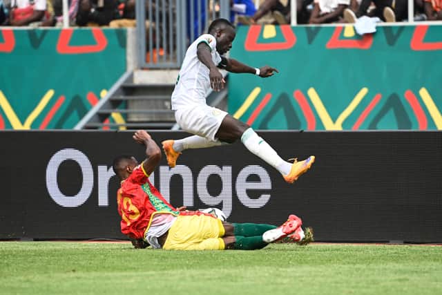 Issiaga Sylla (down) tackles Senegal’s forward Sadio Mane during the Group (Photo by PIUS UTOMI EKPEI/AFP via Getty Images)