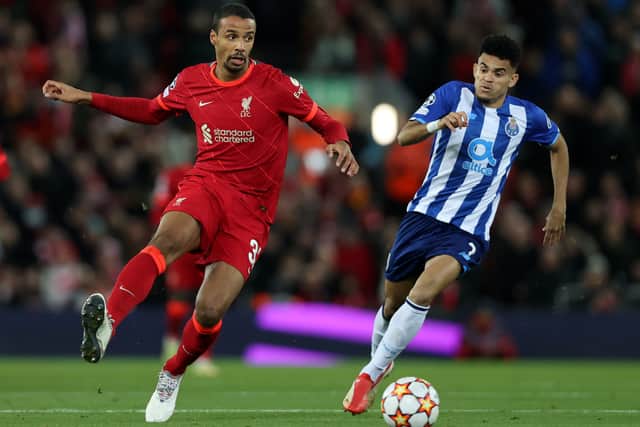 Joel Matip of Liverpool makes a pass whilst under pressure from Luis Diaz of FC Porto during the UEFA Champions League group B match between Liverpool FC and FC Porto at Anfield on November 24, 2021 in Liverpool, England
