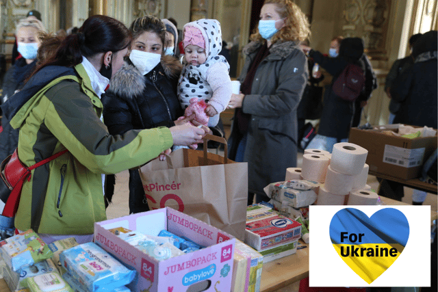 A Ukrainian refugee woman and her daughter receive foods and sanitary articles at an aid point.