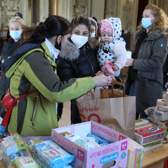 A Ukrainian refugee woman and her daughter receive foods and sanitary articles at an aid point.