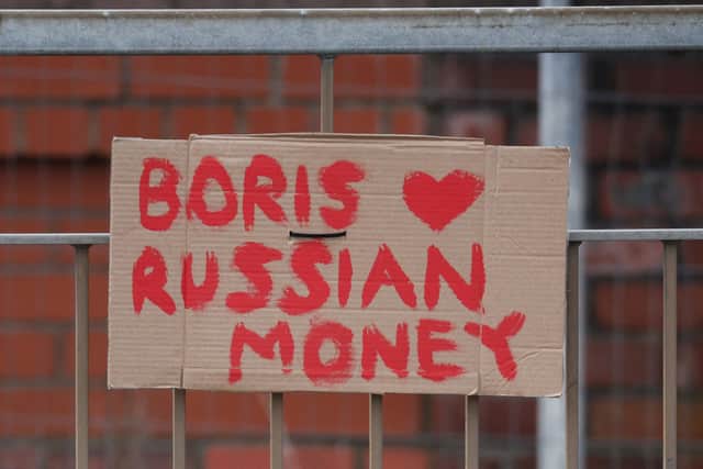 A sign reading “Boris loves Russian money” is attached to a fence near the Cammell Laird shipyard. Photo: PHIL NOBLE/POOL/AFP via Getty Images