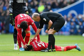 Match referee Mike Dean and Mohamed Salah of Liverpool checks on Luis Diaz who lies injured after a collision with Robert Sanchez. Photo: Mike Hewitt/Getty Images)