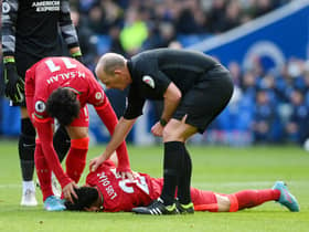 Match referee Mike Dean and Mohamed Salah of Liverpool checks on Luis Diaz who lies injured after a collision with Robert Sanchez. Photo: Mike Hewitt/Getty Images)