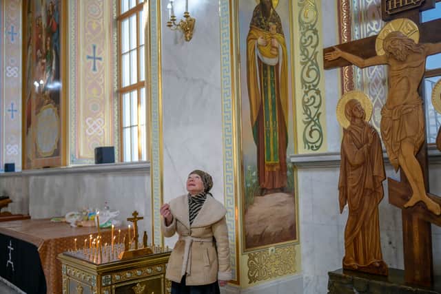 A resident prays in a church of Odessa on March 13, 2022, amid the ongoing Russia’s invasion of Ukraine. Photo: Bulent Kilic/AFP via Getty Images)