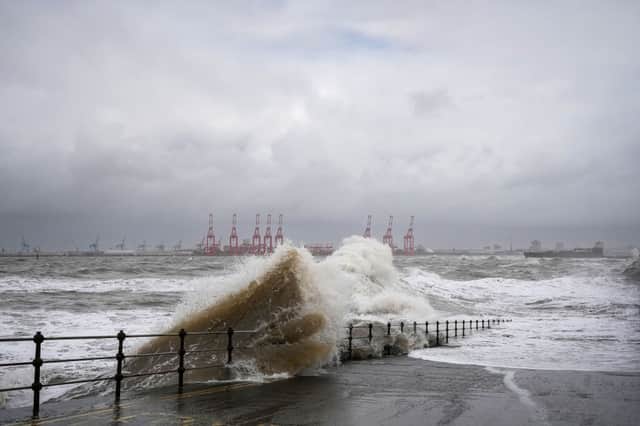 People view the waves created by high winds and spring tides hitting the sea wall at New Brighton promenade on February 17, 2022 in Liverpool. Photo: Christopher Furlong/Getty Images.