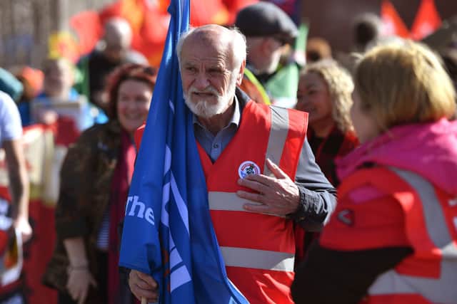 A man attaches a sticker to his vest as demonstrators gather outside the entrance to the Port of Liverpool. Photo: Anthony Devlin/Getty Images