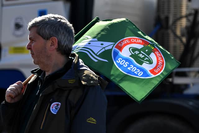  A man holds a flag in support of seafarers as demonstrators gather outside the entrance to the Port of Liverpool. Photo: Anthony Devlin/Getty Images