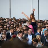 Racegoers cheer as they watch their horse win at Aintree.