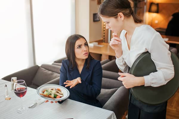 Upset young businesswoman complains about her food. Image: estradaanton - stock.adobe.com