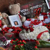 Photographs, wreathes of flowers and messages are pictured at the eternal flame of the Hillsborough memorial. Image: PAUL ELLIS/AFP via Getty