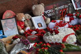 Photographs, wreathes of flowers and messages are pictured at the eternal flame of the Hillsborough memorial. Image: PAUL ELLIS/AFP via Getty