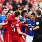 Sadio Mane of Liverpool (hidden) is shown a yellow card by referee Stuart Attwell during the Premier League match between Liverpool and Everton at Anfield on April 24, 2022 in Liverpool, England. (Photo by Clive Brunskill/Getty Images)