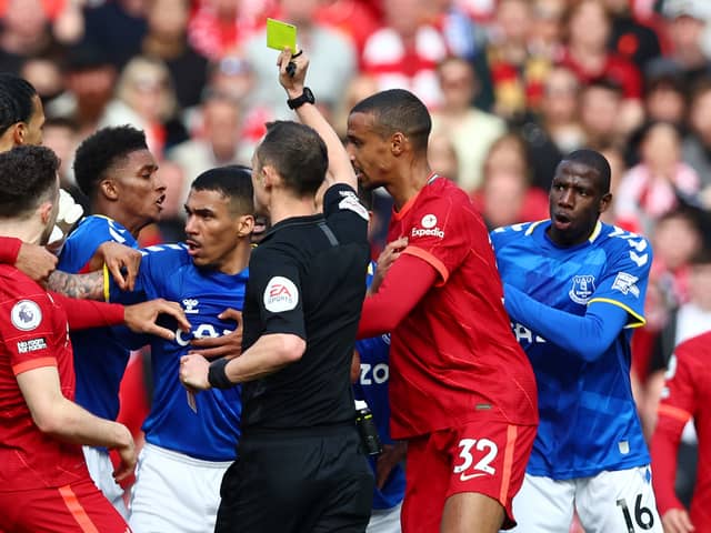 Sadio Mane of Liverpool (hidden) is shown a yellow card by referee Stuart Attwell during the Premier League match between Liverpool and Everton at Anfield on April 24, 2022 in Liverpool, England. (Photo by Clive Brunskill/Getty Images)