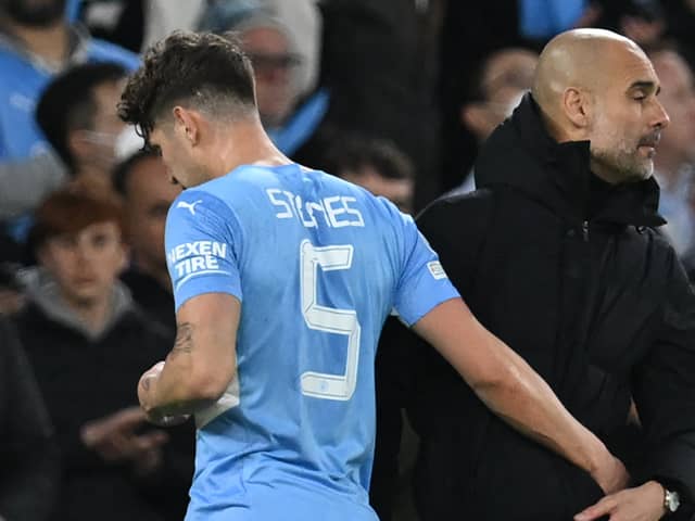 John Stones is embraced by Pep Guardiola after limping off in Man City’s Champions League win against Real Madrid. Picture: PAUL ELLIS/AFP via Getty Images