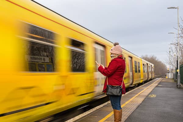 A  woman on her phone as a Merseyrail train approaches. Image: Gabriel - stock.adobe.com