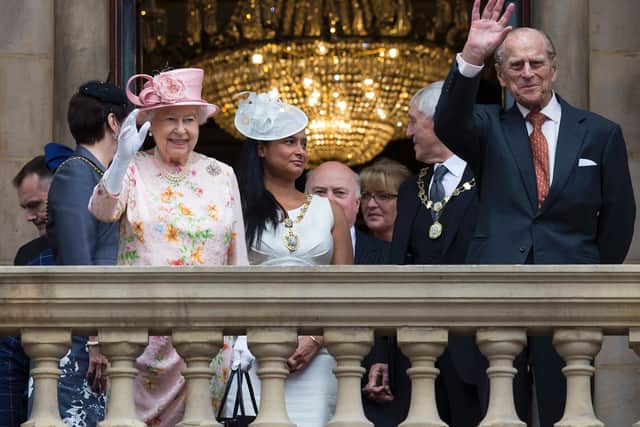 Queen Elizabeth II and her husband Prince Philip, Duke of Edinburgh waves to members of the public from the balcony of Liverpool Town Hall. She has a day of engagements in Liverpool, where she will attend the International Festival for Business 2016, and officially open Alder Hey Children’s Hospital.