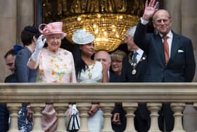 Queen Elizabeth II and her husband Prince Philip, Duke of Edinburgh wave to members of the public from the balcony of Liverpool Town Hall in 2016. 