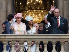 Queen Elizabeth II and her husband Prince Philip, Duke of Edinburgh wave to members of the public from the balcony of Liverpool Town Hall in 2016. 