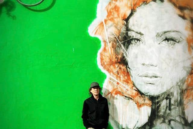 Mick Jagger poses in front of some street art. Image: @MickJagger/twitter