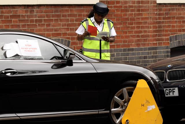 A traffic warden clamps a car. Photo: Oli Scarff/Getty Images