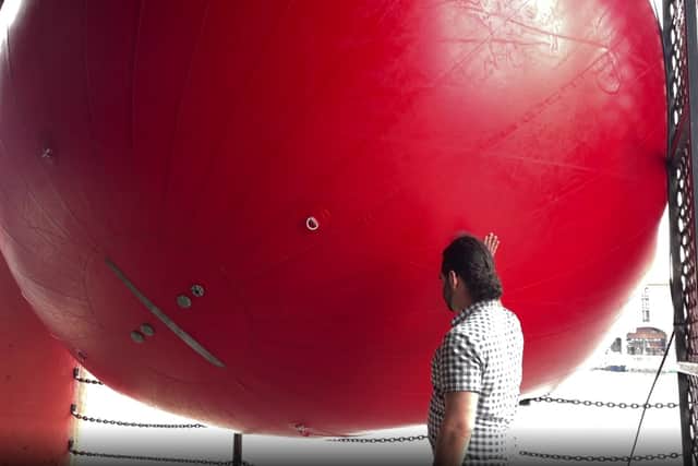 A member of the public can’t resist touching the RedBall.