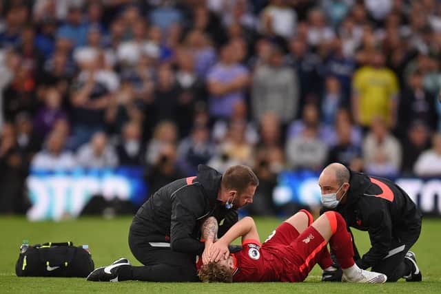 Harvey Elliott receives treatment from Dr Jim Moxon and physio Chris Morgan following his horrific ankle injury against Leeds United. Picture: OLI SCARFF/AFP via Getty Images