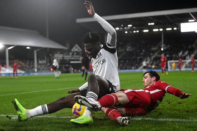  Ola Aina of Fulham is tackled by Andrew Robertson of Liverpool  during the Premier League match between Fulham and Liverpool in 2020.