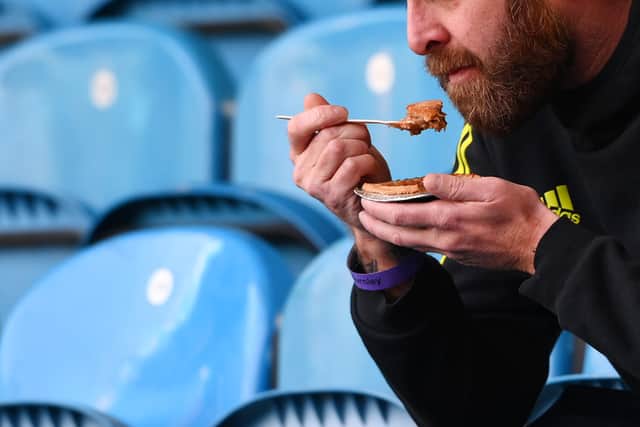 A football fan eats a pie. Photo: Stu Forster/Getty Images