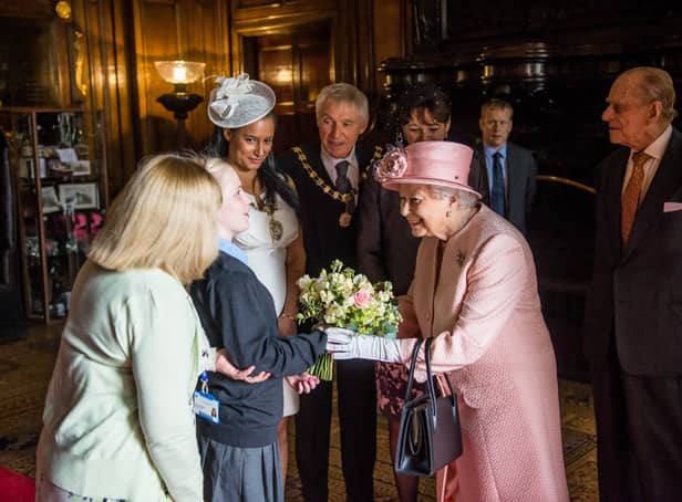 <p>Queen Elizabeth II receives flowers from a student at St Vincent’s School in 2016.</p>