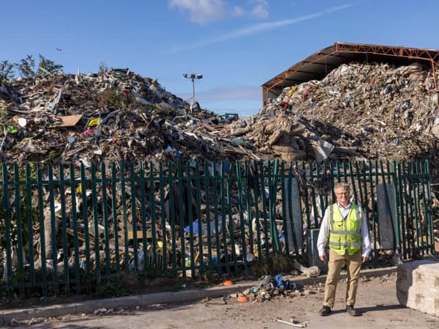 <p>Jeremy Poupard, the manager at MST Group, standing in front of the rubbish pile next door. Credit: Liverpool Echo.</p>