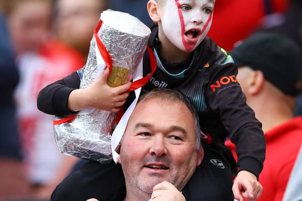 A young fan of St Helens carries a replica of the Grand Final Trophy prior to kick off. (Photo by Michael Steele/Getty Images)