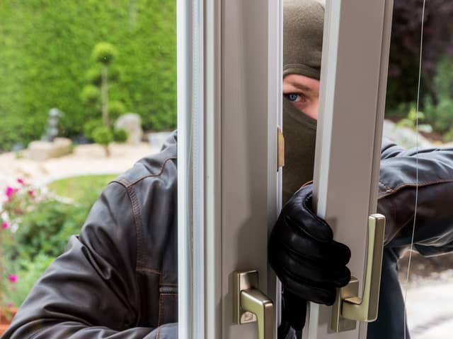 A burglar tries to break in an open window with a crowbar. Image: Gina Sanders - stock.adobe.com