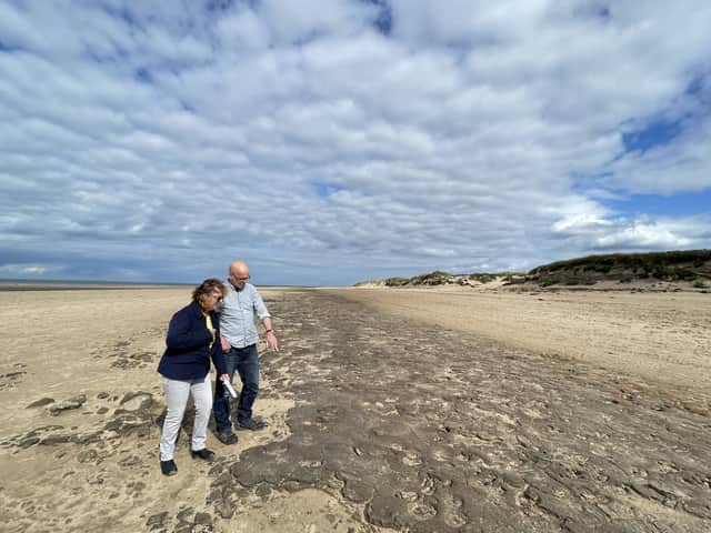 <p>Dr Alison Burns and Professor Jamie Woodward inspecting 8500-year-old animal and human footprints in one of the Mesolithic mud beds at Formby. Image: Jamie Woodward/SWNS</p>